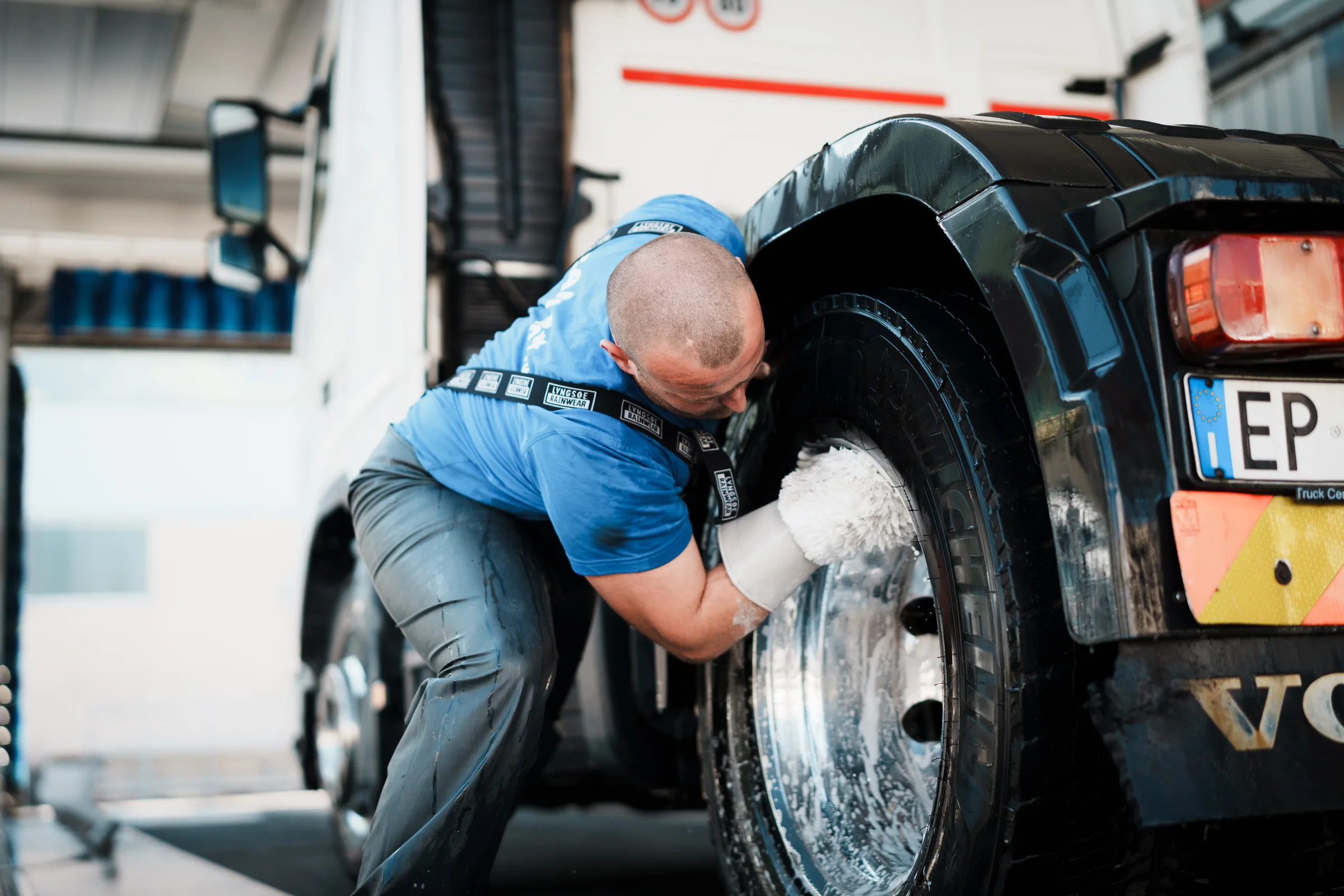 Pulizia accurata di uno pneumatico di camion con guanto da lavaggio